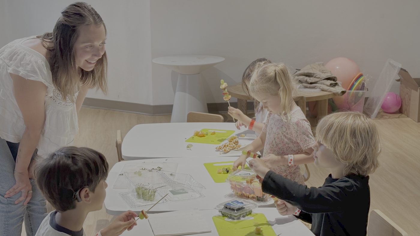 Children in a Dr. Yum inspired sensory cooking class exploring fresh food with a pediatric feeding therapist